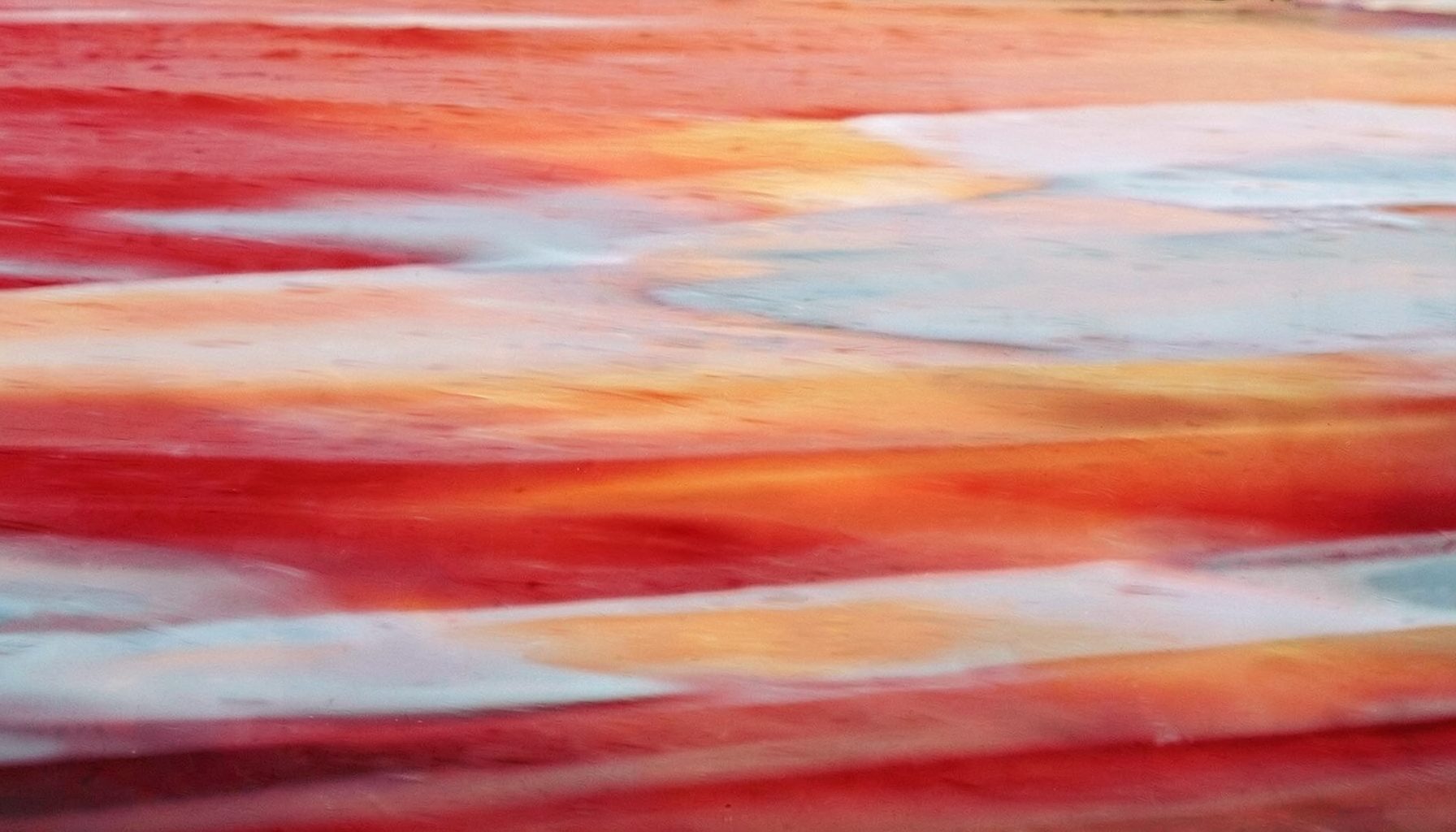 A luminous abstract seascape with layered washes of crimson, ochre, and pale blue suggesting tidal movement